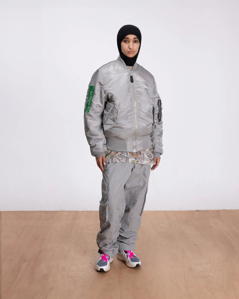 Model wearing the silver Patta x Alpha Industries MA-1 Celebration bomber jacket.