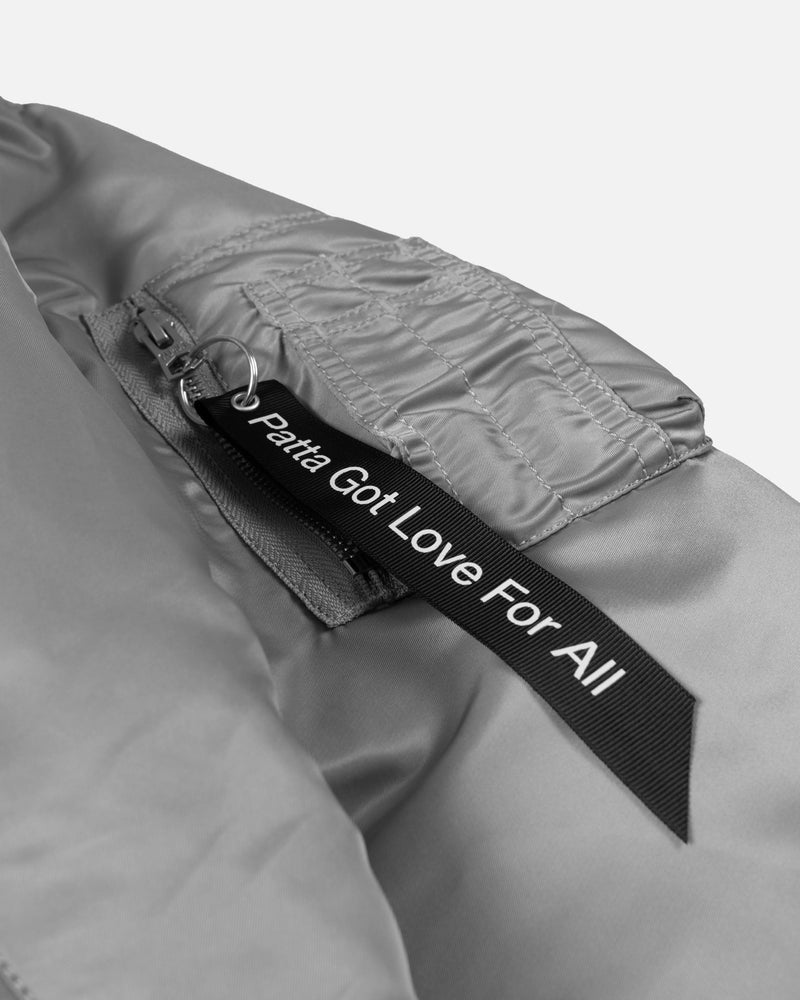 Sleeve utility pocket and branded tag on the silver Patta x Alpha Industries MA-1 bomber jacket.