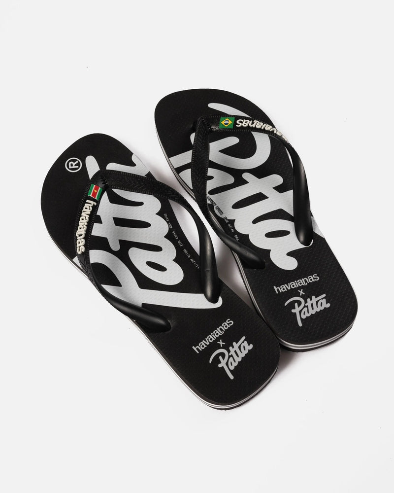 Patta x Havaianas black flip-flops with bold white logo branding across rubber footbeds.