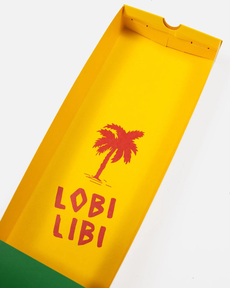 Yellow interior of the Patta x Havaianas packaging box with red palm tree graphic and Lobi Libi text.