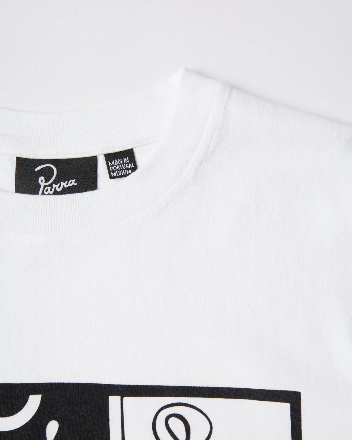 Close-up of the collar and branded neck label on the white ByParra Our House T-shirt.