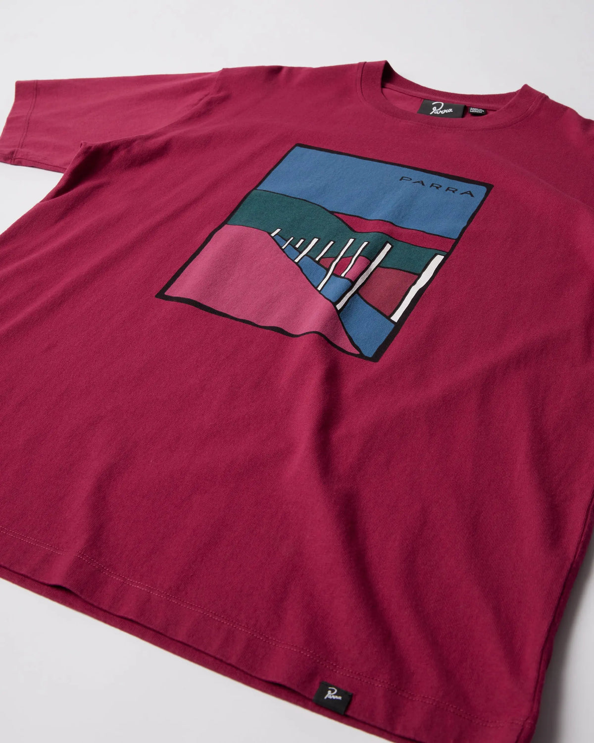 Close-up of the raspberry ByParra Beach Parking T-shirt featuring the printed chest graphic.