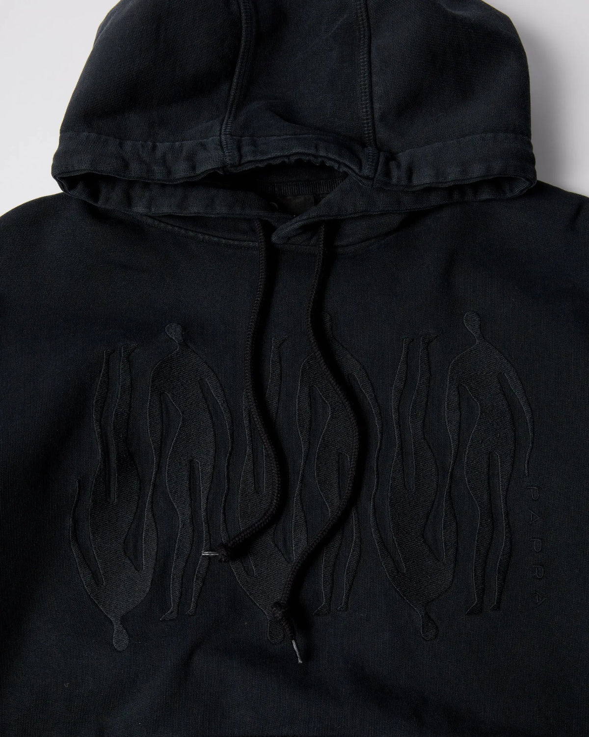 Close-up of the black ByParra Connected Guy hoodie featuring tonal figure embroidery on the chest.