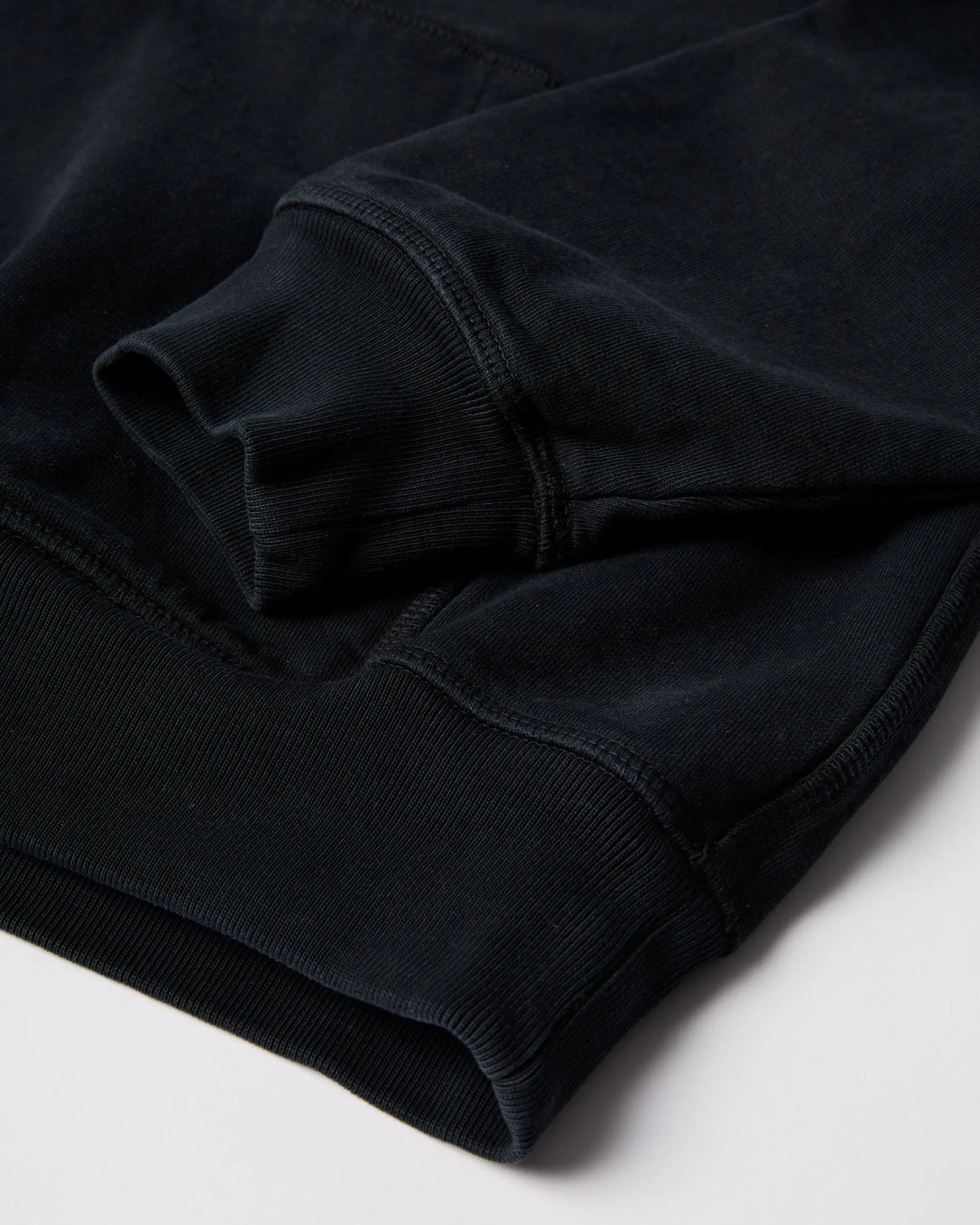 Close-up of the ribbed cuff and hem on the black ByParra Connected Guy Hooded Sweatshirt.