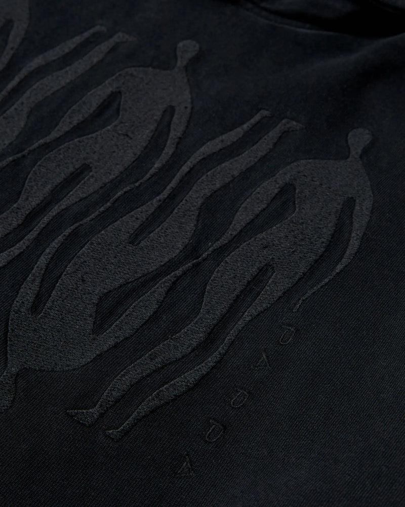 Close-up of black tonal embroidered figures on the ByParra Connected Guy hooded sweatshirt.