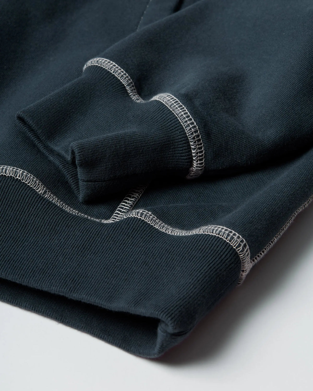 Close-up of the ribbed cuff and contrast stitching on the byParra dark blue hooded sweatshirt.