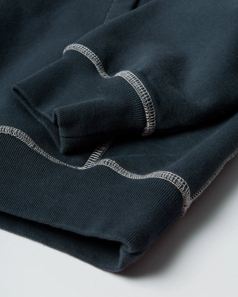 Close-up of the ribbed cuff and contrast stitching on the byParra dark blue hooded sweatshirt.