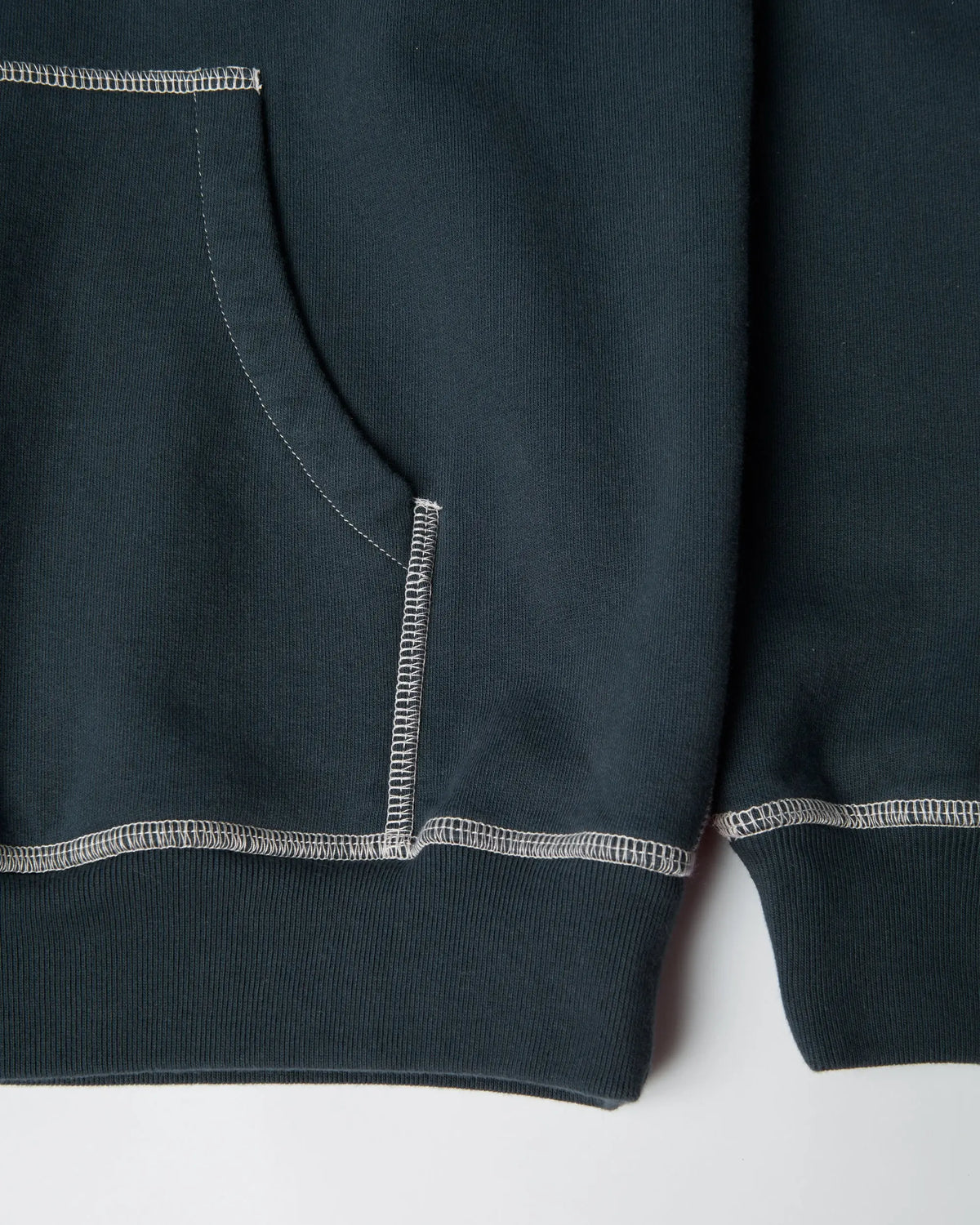 Close-up of white contrast stitching and pocket on the byParra Dark Blue Hooded Sweatshirt.
