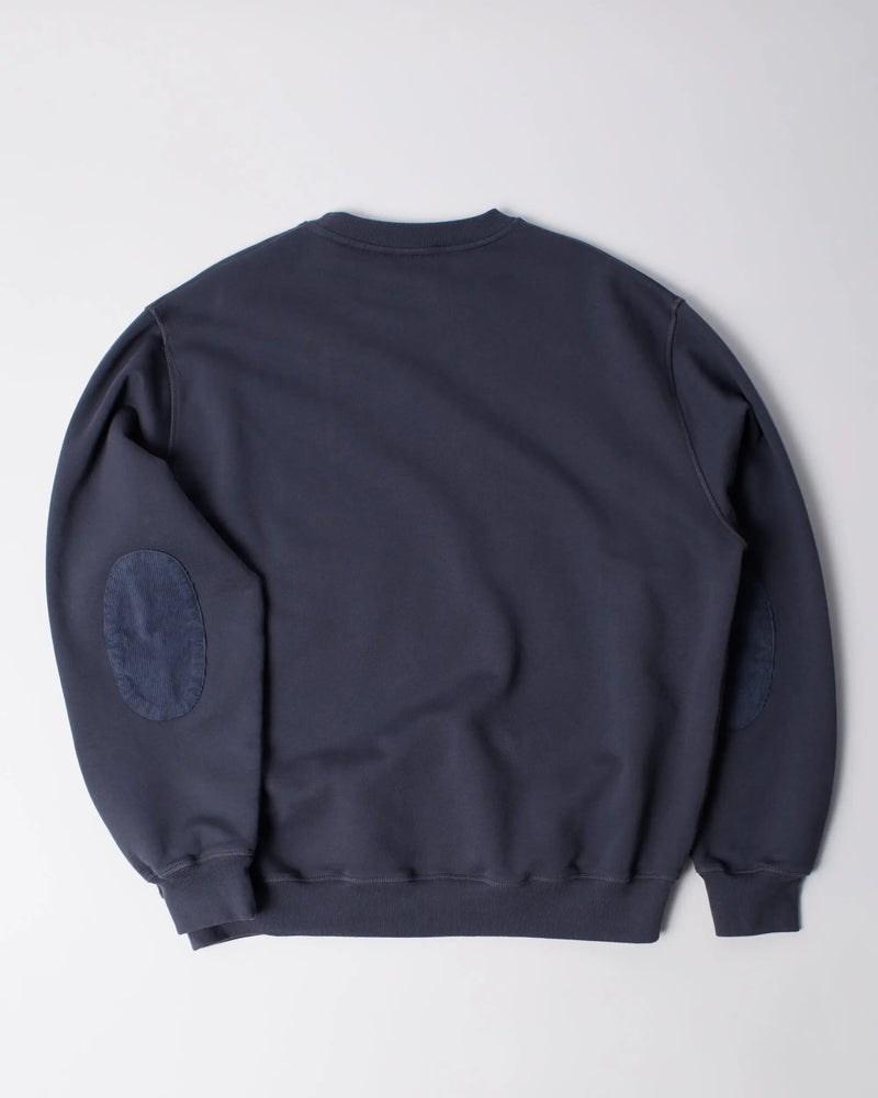 Back view of the byParra Tired Champione crew neck sweatshirt in navy blue with elbow patches.