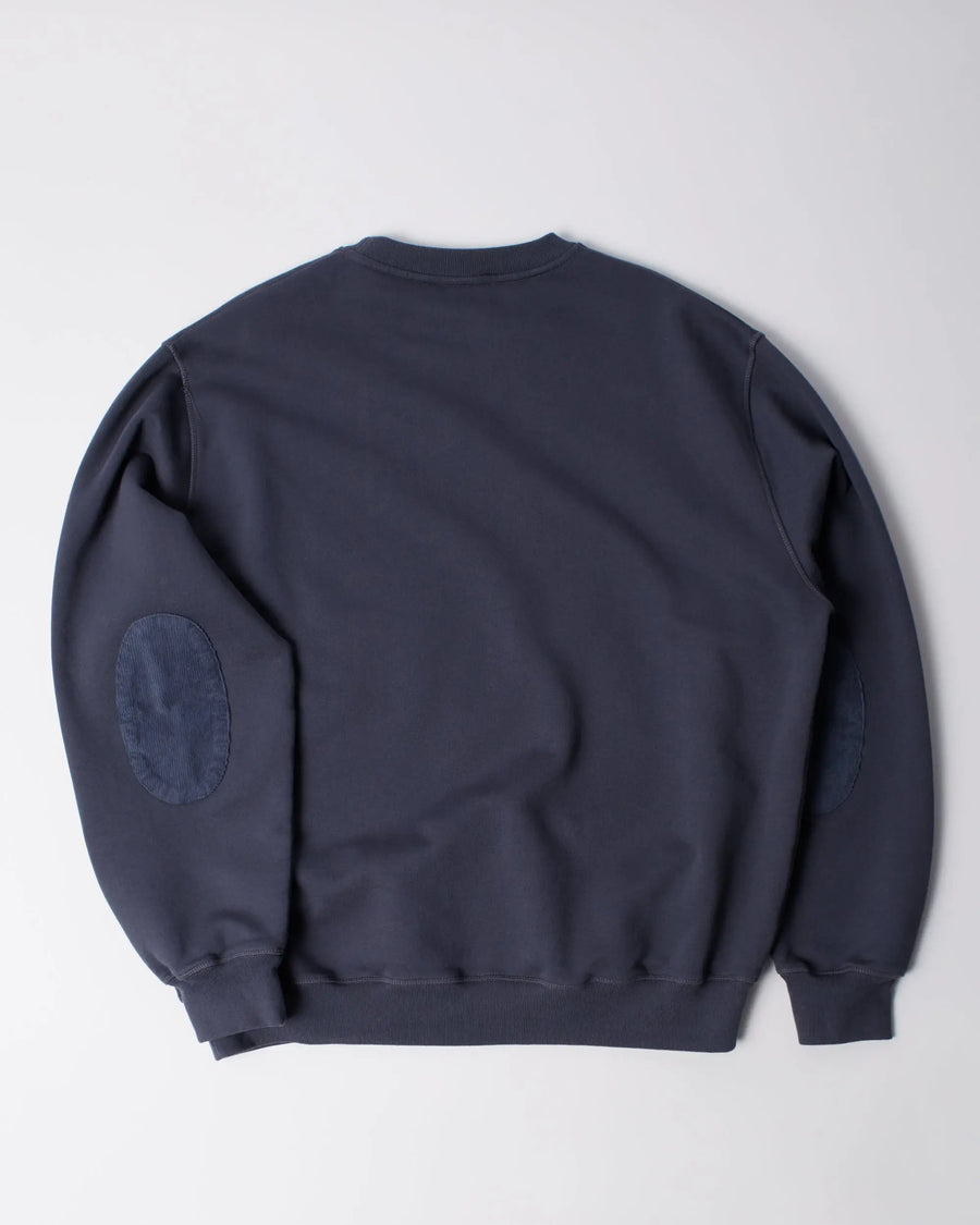 Back view of the byParra Tired Champione crew neck sweatshirt in navy blue with elbow patches.