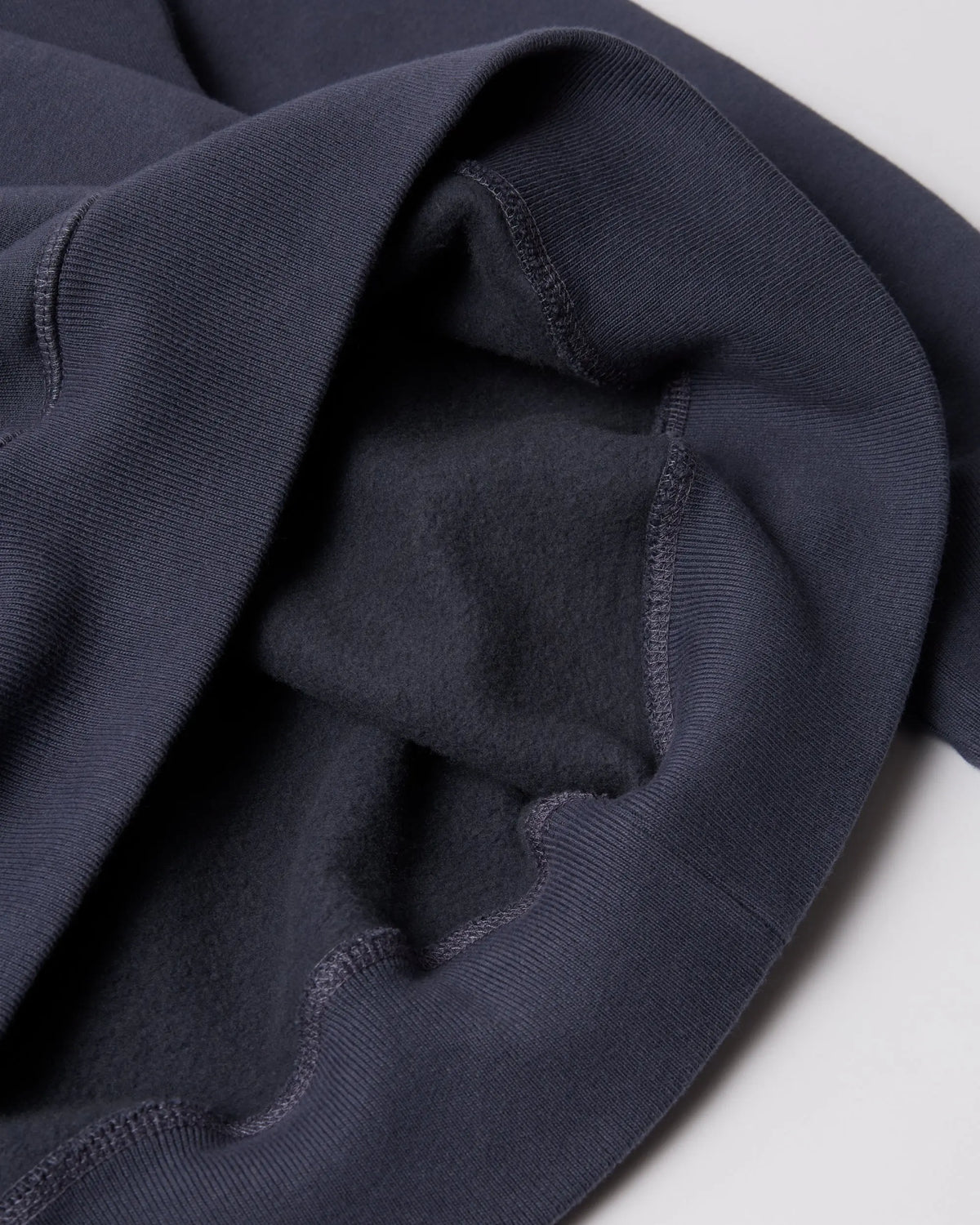 Interior fleece lining and ribbed hem detail of the navy blue byParra crew neck sweatshirt.