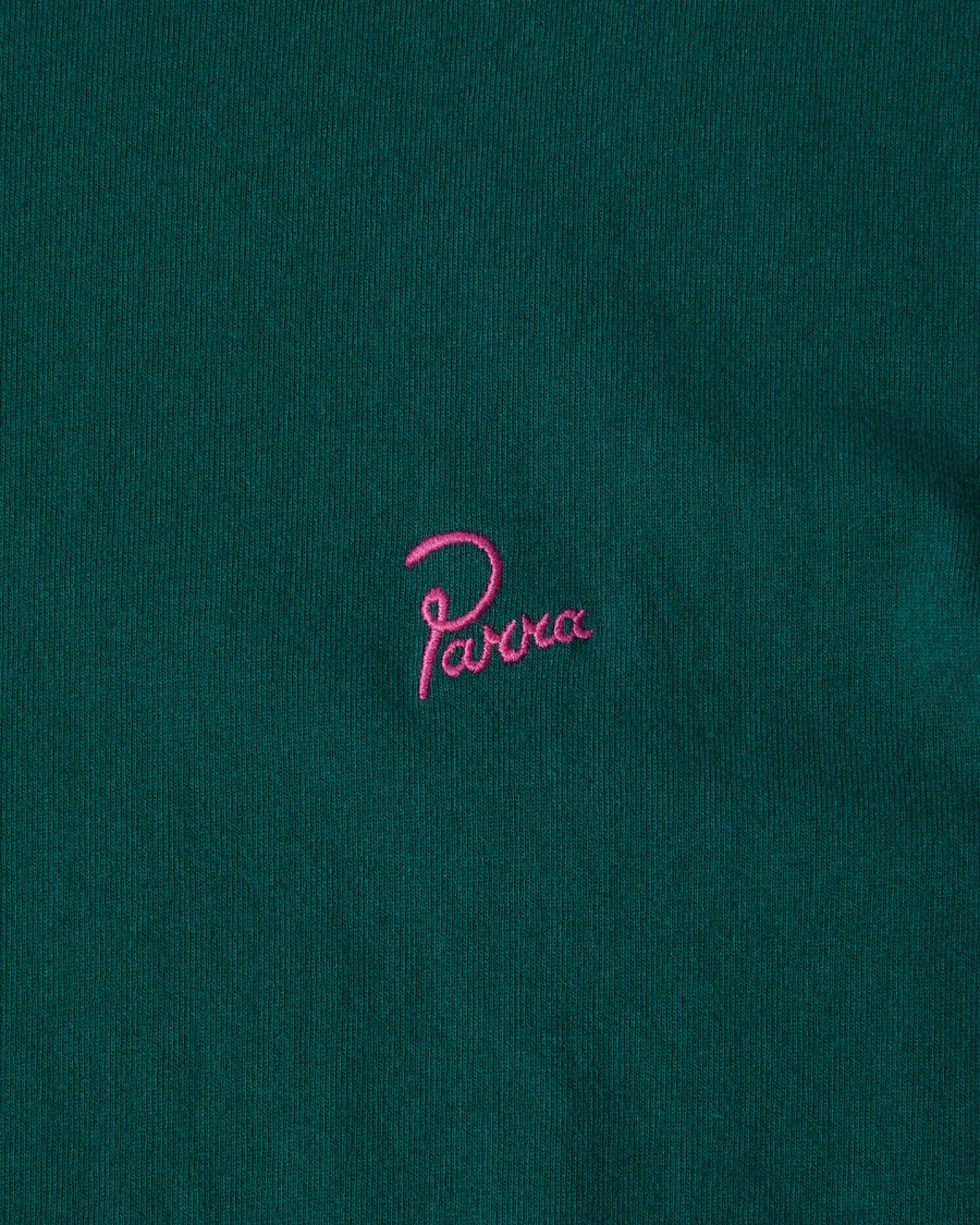 Close-up of pink embroidered Parra signature logo on a dark green cotton T-shirt.