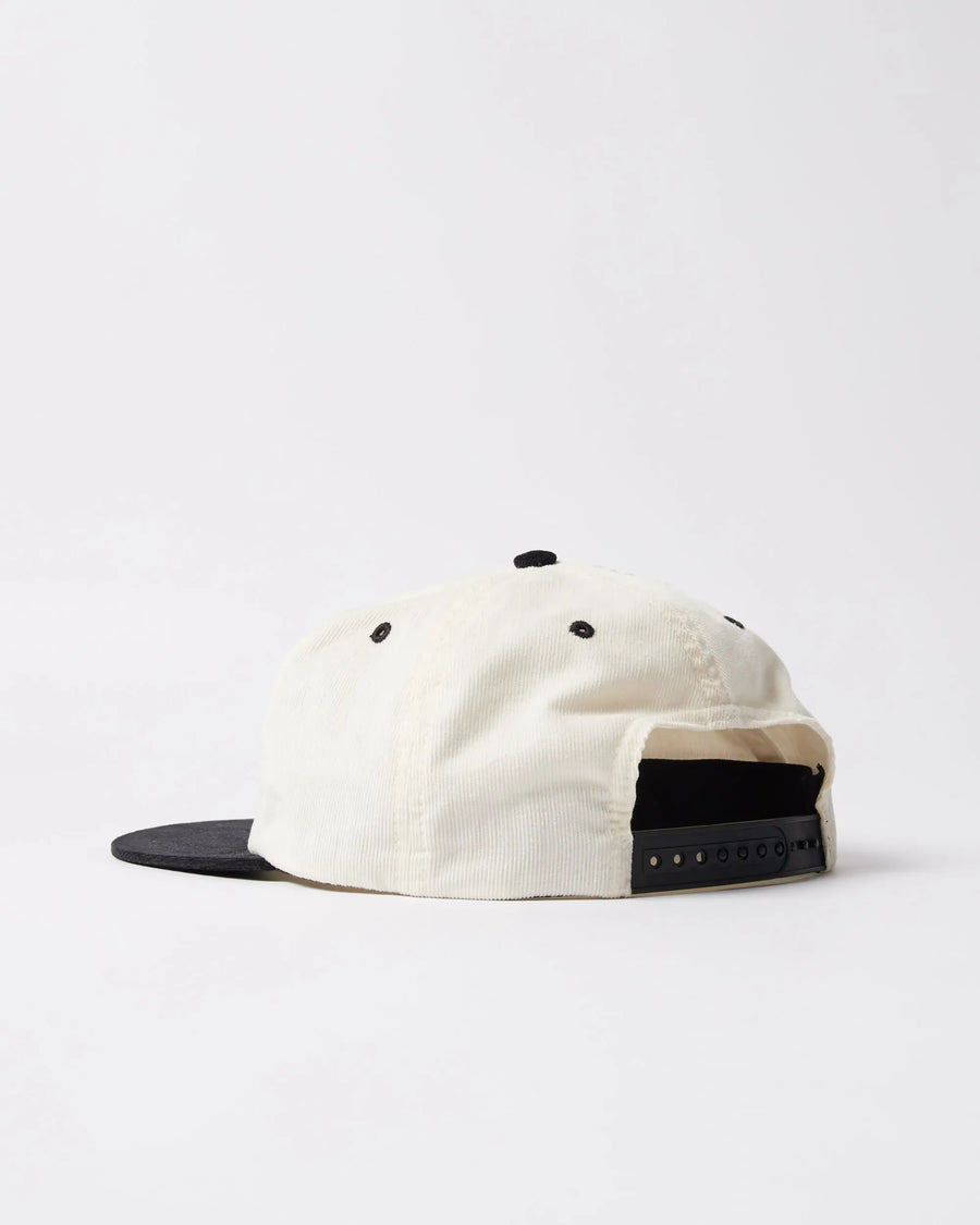 Back view of the byParra Error Logo 6 Panel Hat in off-white corduroy with an adjustable black snapback closure.