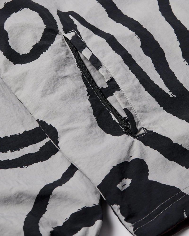 Close-up of the grey abstract print and zipper pocket on the byParra Freak Scene Reversible Track Top.