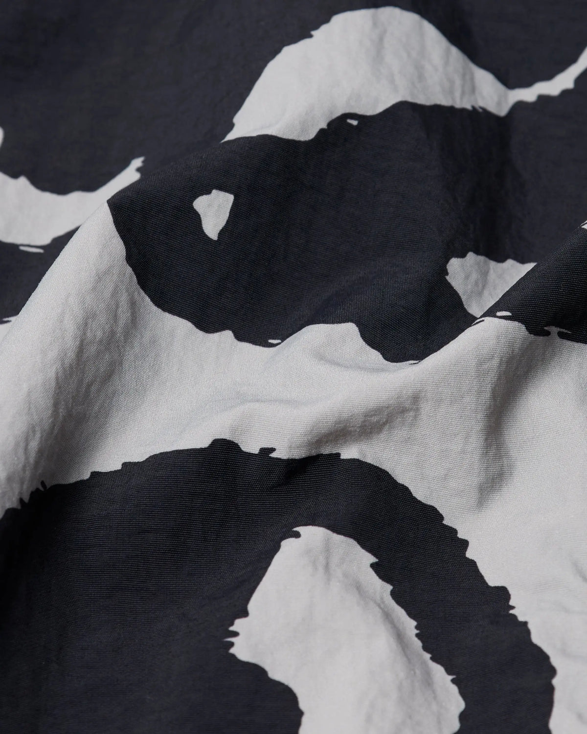 Close-up of the black and grey patterned nylon on the byParra Freak Scene Reversible Track Top.