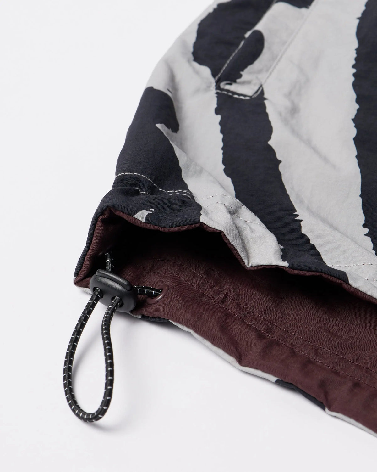 Close-up of the drawstring toggle hem on the byParra Freak Scene Reversible Track Top in grey.