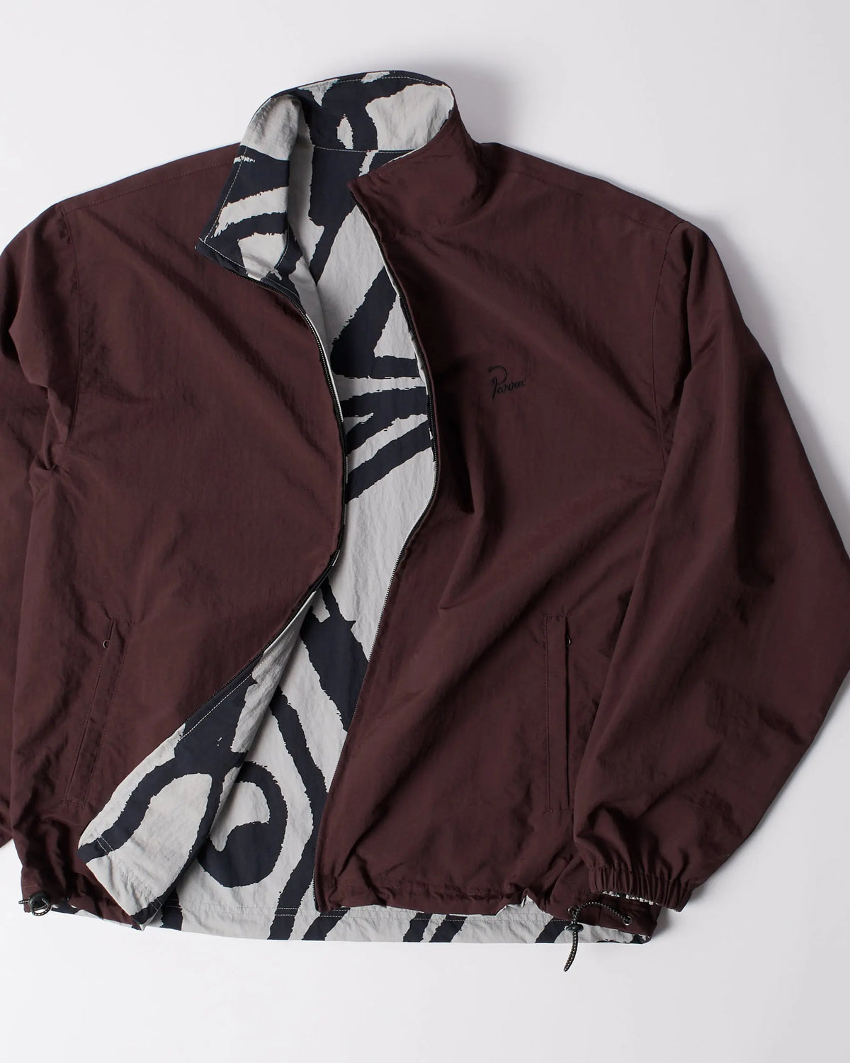 byParra Freak Scene Reversible Track Top unzipped, showing a brown shell and graphic patterned lining.