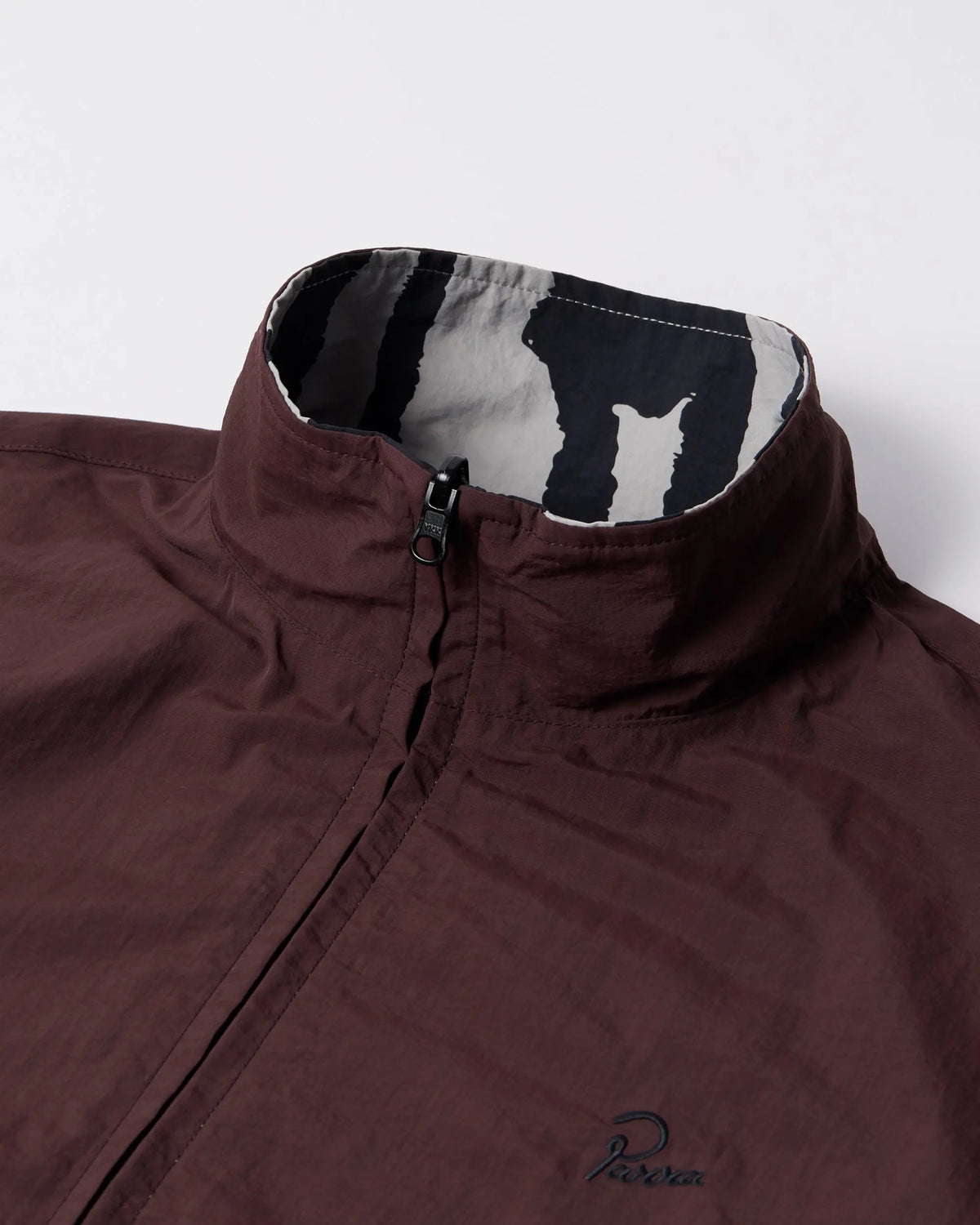 Collar detail of the byParra Freak Scene reversible track top in brown with patterned inner lining.