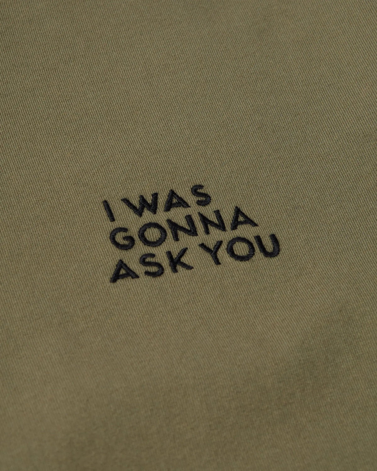 Black embroidered 'I WAS GONNA ASK YOU' text detail on a green By Parra cotton t-shirt.