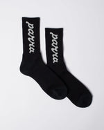 Black By Parra ribbed crew socks featuring a white lowercase script logo knit on the leg.