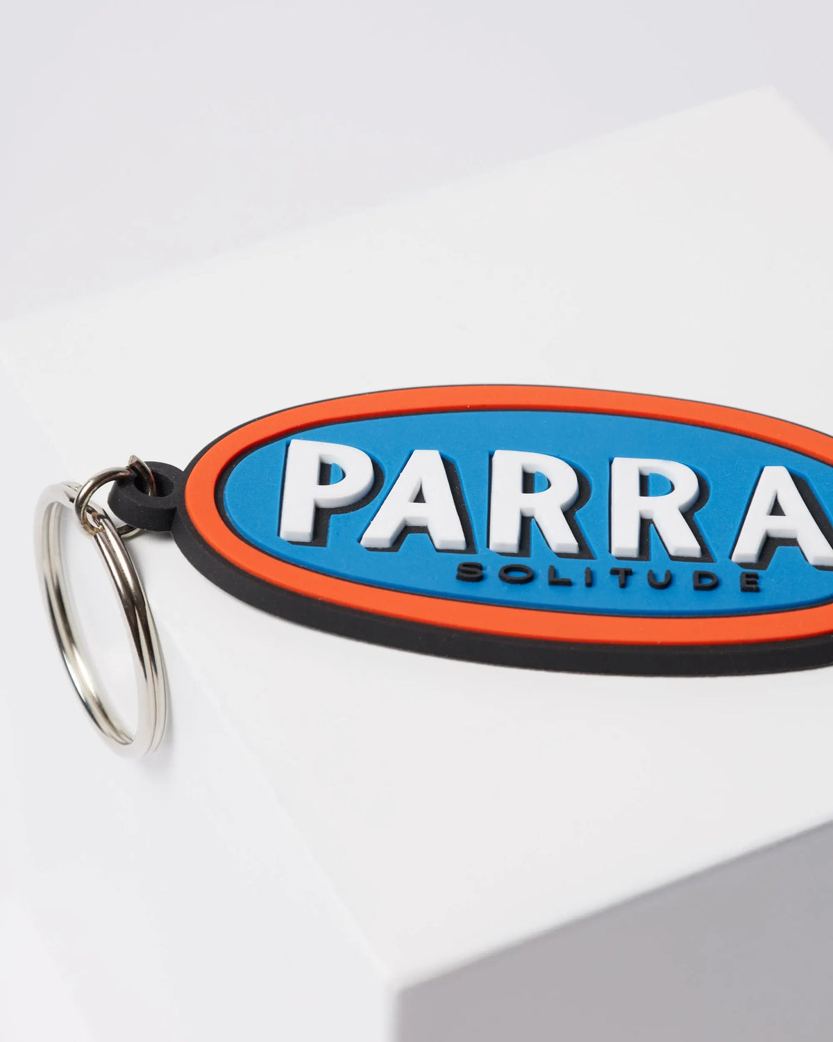 Close-up of By Parra Lonely blue rubber keychain with embossed Parra Solitude lettering.