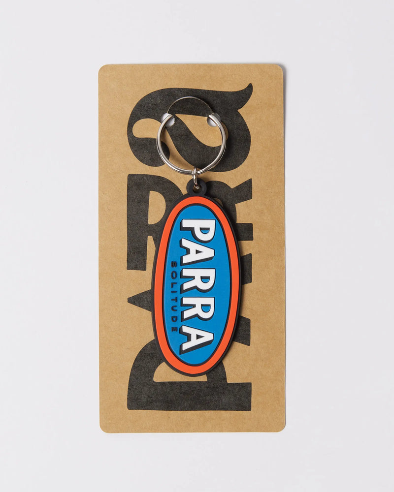 By Parra Lonely rubber keychain in blue and orange, displayed on branded cardboard packaging.