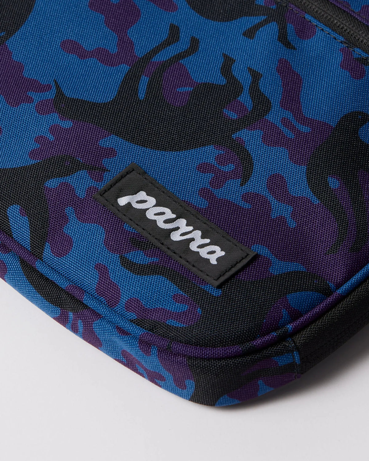 Close-up of the By Parra Purple Camo Beast laptop sleeve in blue, highlighting the stitched Parra logo patch.