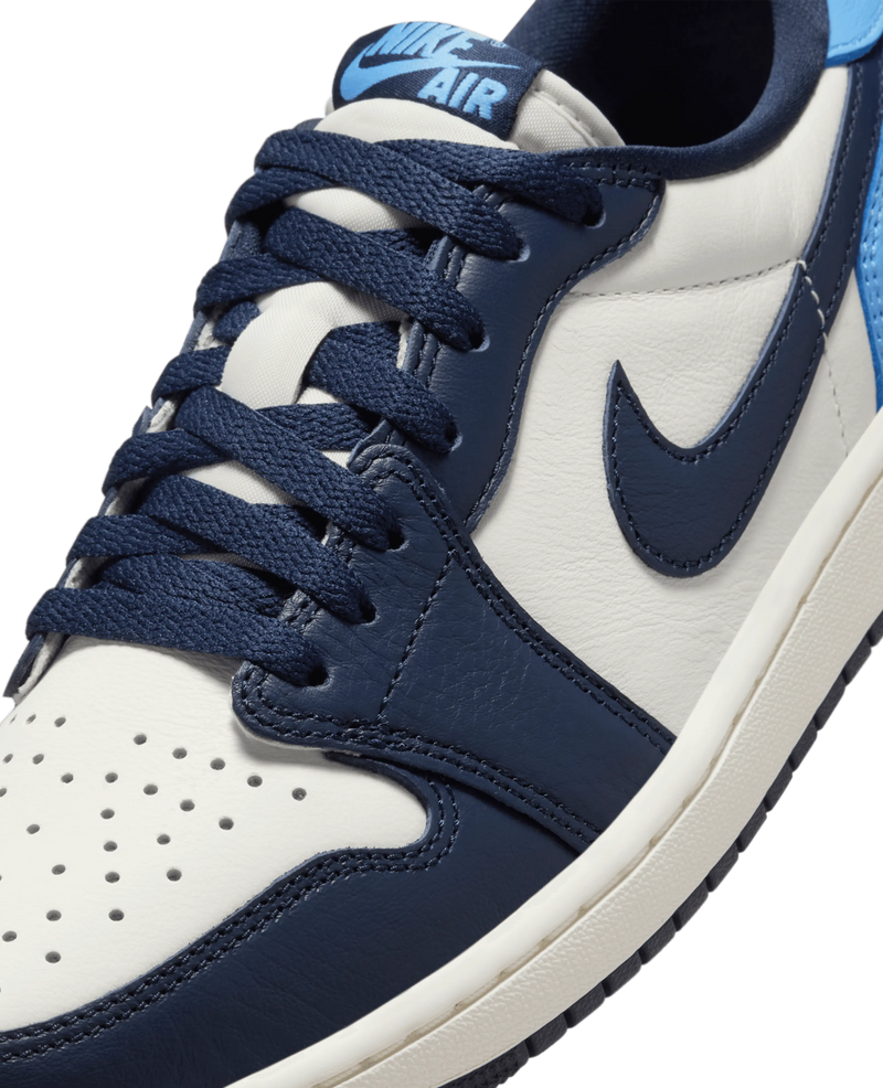 Close-up of the Air Jordan 1 Low OG Obsidian leather sneaker with navy laces and Nike Air tongue tag.