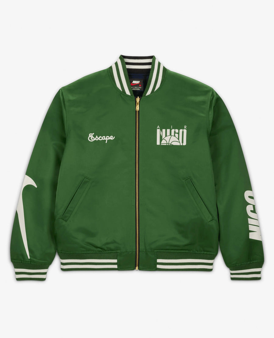 Nike x NIGO NRG coach jacket in forest green featuring embroidered graphics and striped trim.