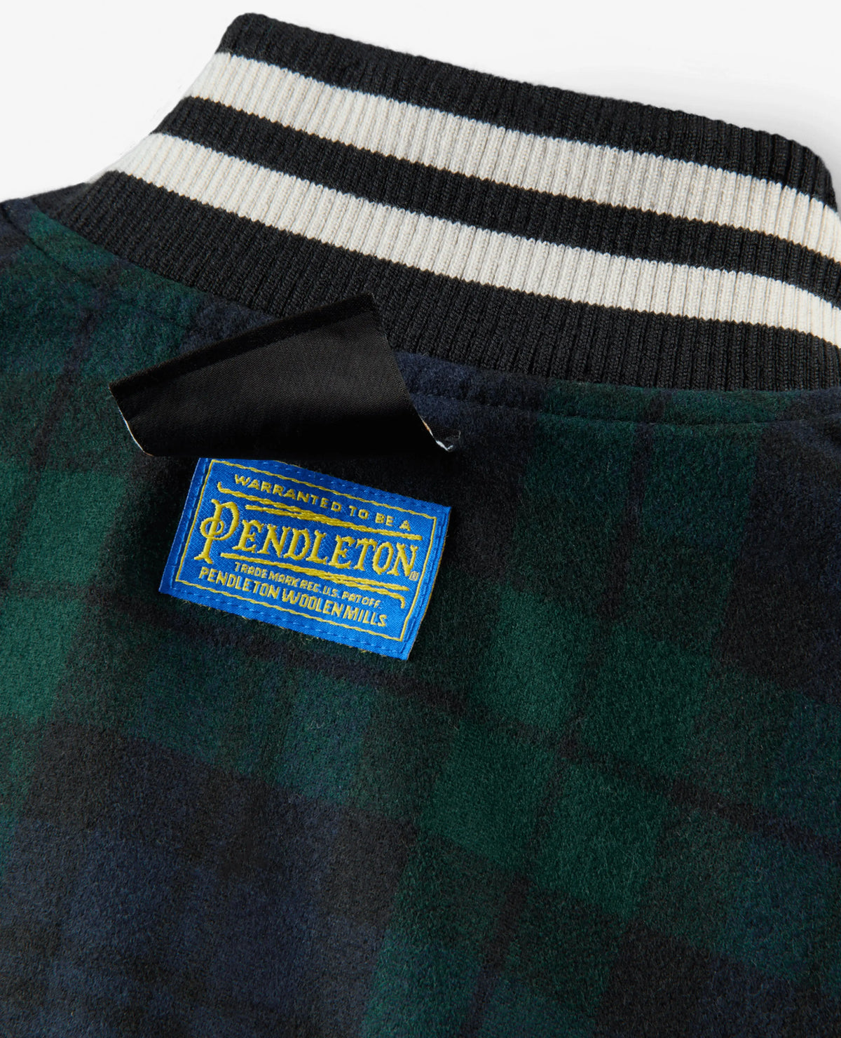Blue Pendleton woven label on the Nike x NIGO green plaid wool jacket with striped ribbed collar.