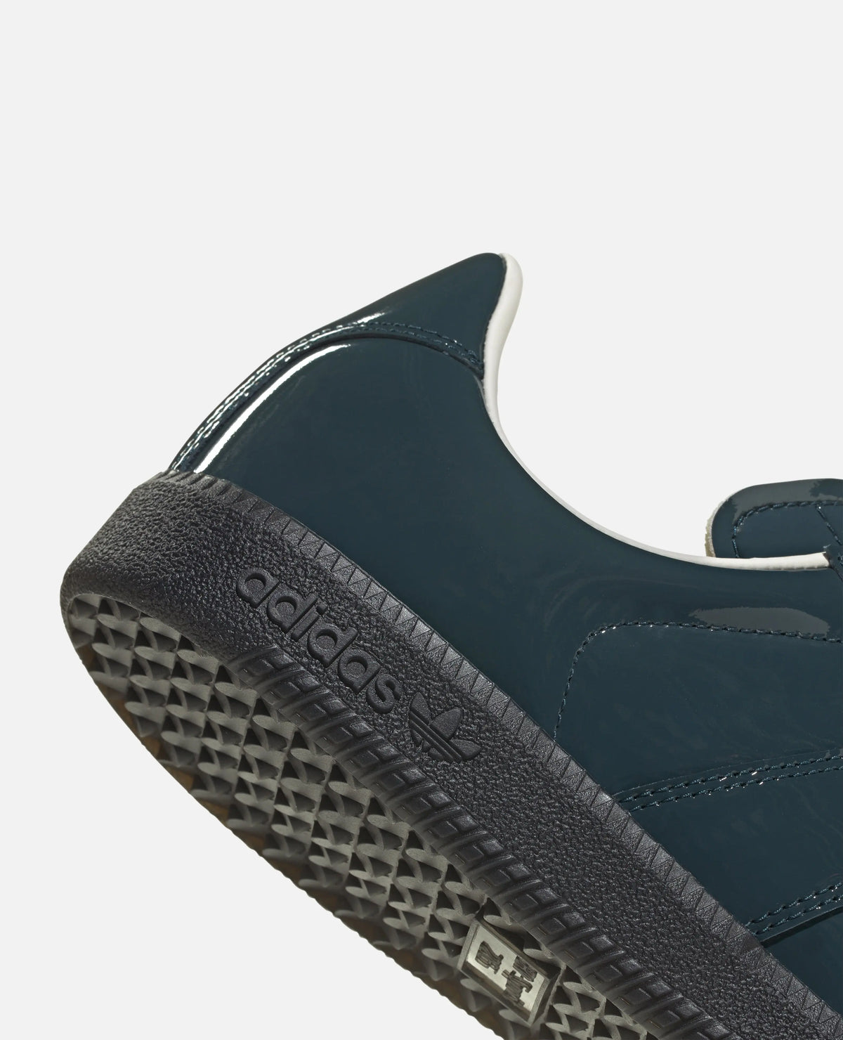 Close-up heel detail of the adidas BW Army sneaker in glossy dark patent leather with embossed branding.