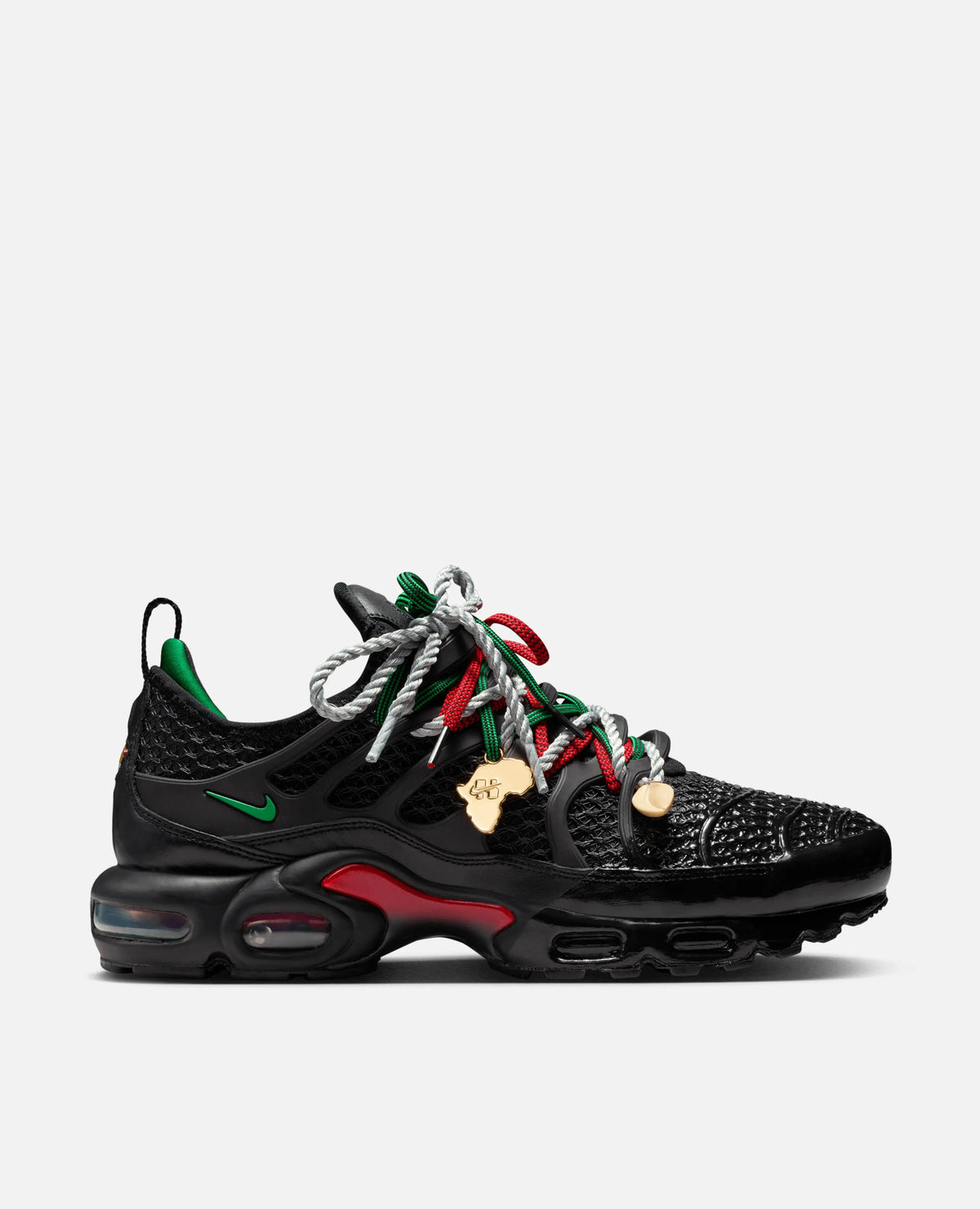 Side profile of HOMECOMING x Nike Air Max Plus in black with Pan-African red and green accents.
