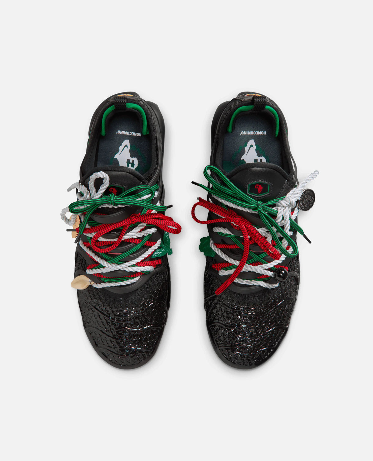 Top-down view of HOMECOMING x Nike Air Max Plus Pan African sneakers with textured uppers and colorful laces.