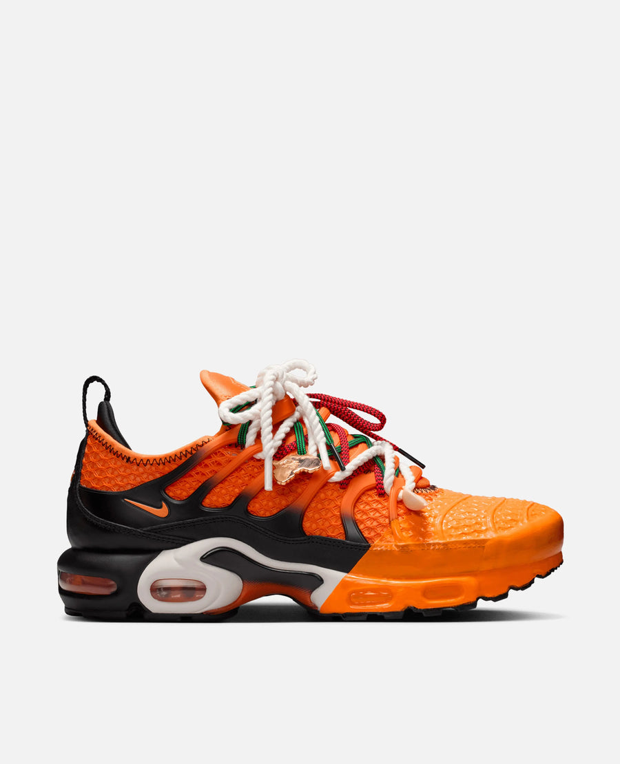 Side profile of the HOMECOMING x Nike Air Max Plus in Safety Orange and black with decorative layered rope laces.