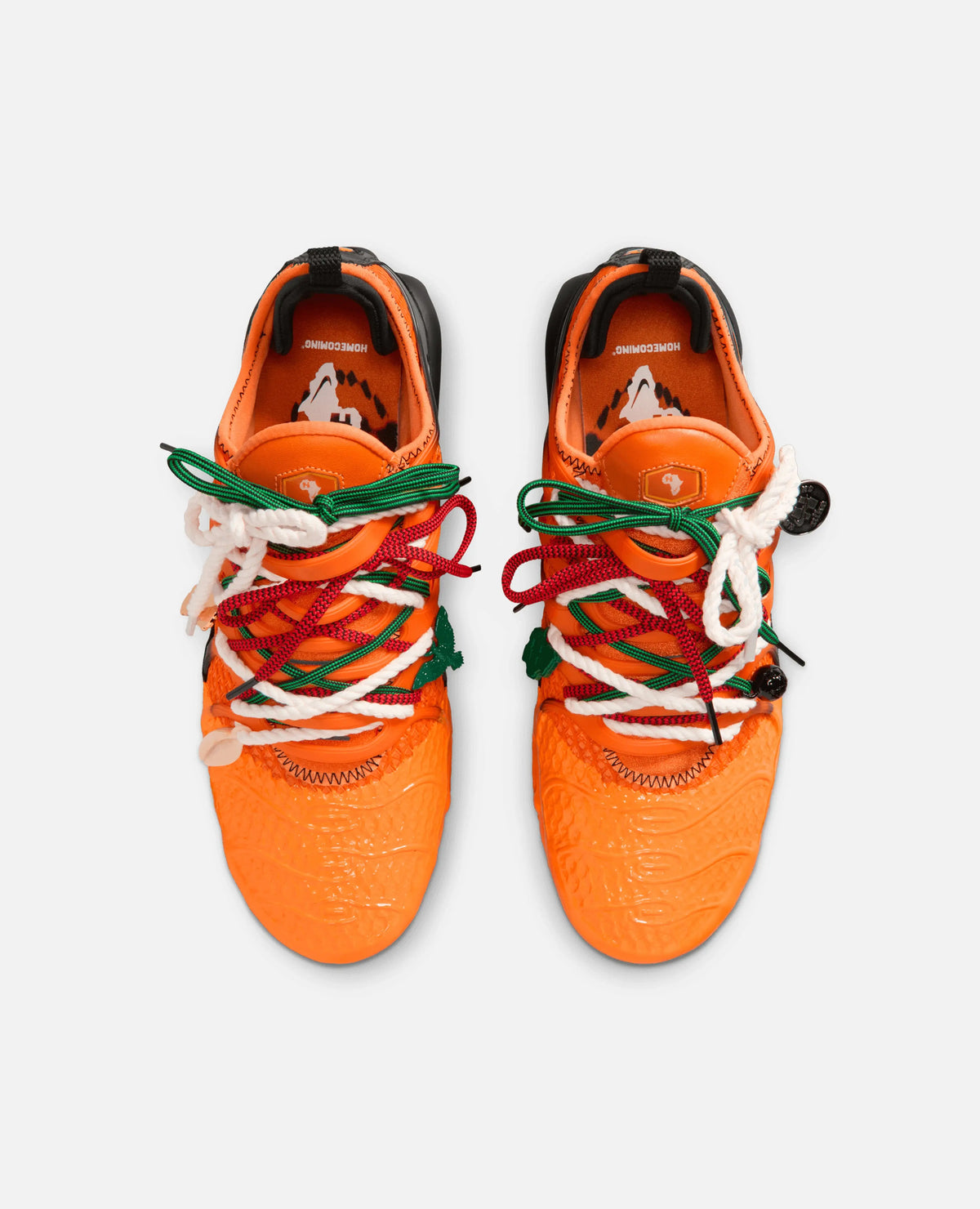Top-down view of HOMECOMING x Nike Air Max Plus sneakers in safety orange with layered laces.