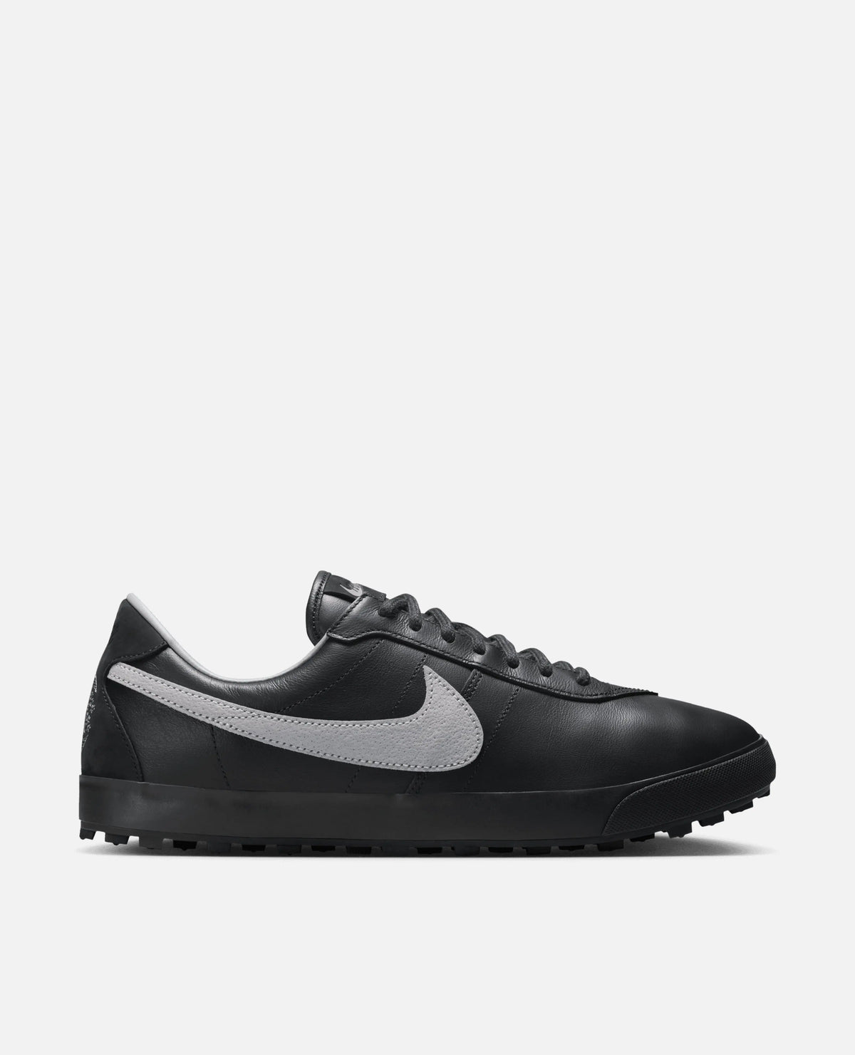 Side profile of the Nike Astrograber sneaker in Off Noir leather with a Cement Grey Swoosh.