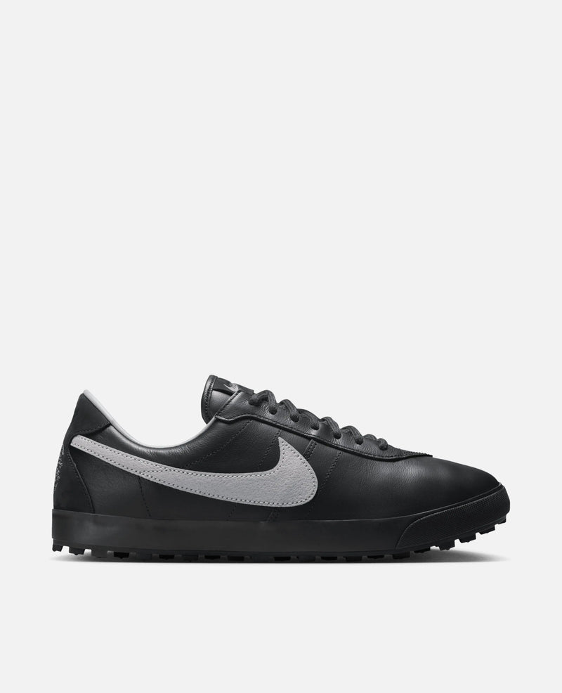 Side profile of the Nike Astrograber sneaker in Off Noir leather with a Cement Grey Swoosh.