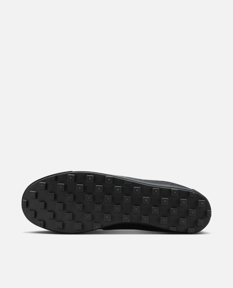 Black waffle rubber outsole of the Nike Astrograbber sneaker in Off Noir and Cement Grey.