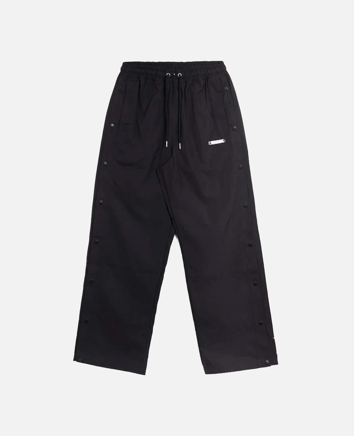 Front view of Nike Jordan x FTY men's black track pants featuring side snap buttons.