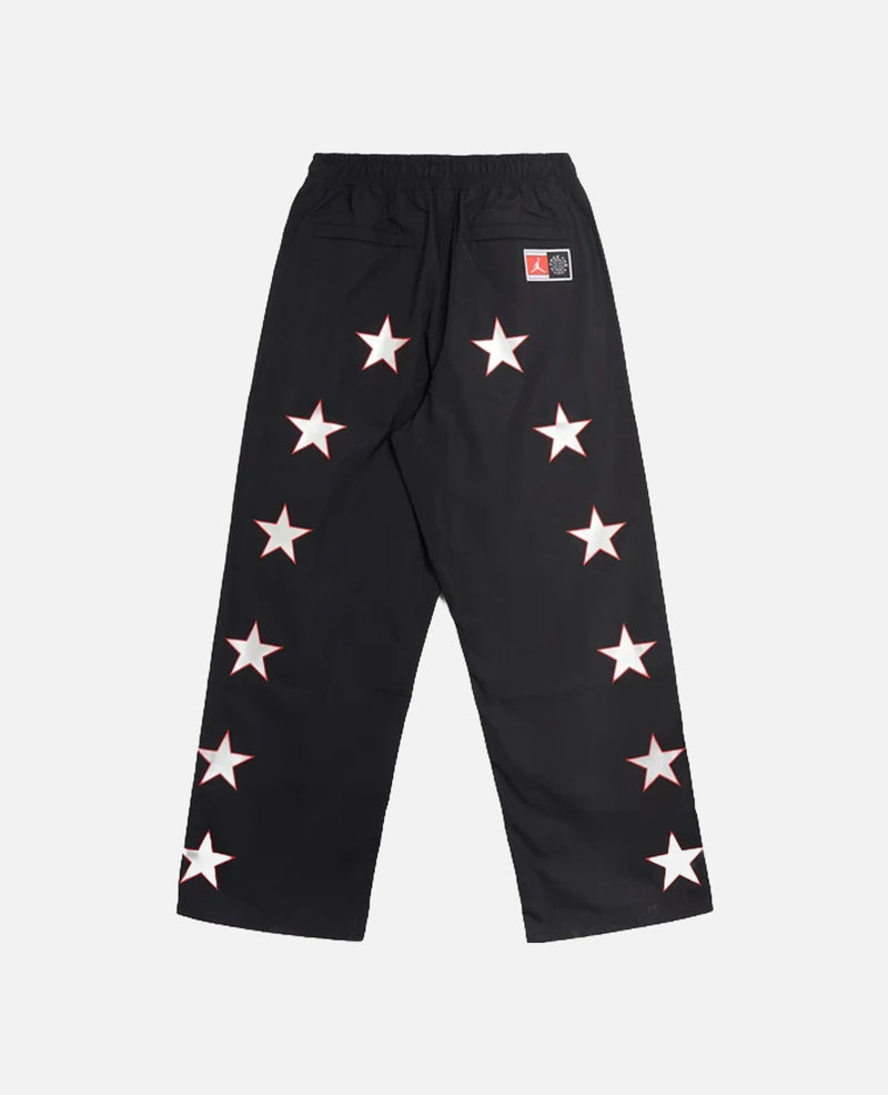 Back view of Nike Jordan x FTY black track pants with white star graphics along the legs.