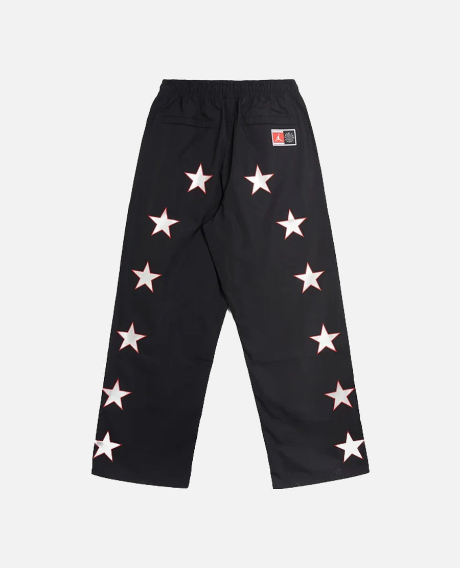 Back view of Nike Jordan x FTY black track pants with white star graphics along the legs.