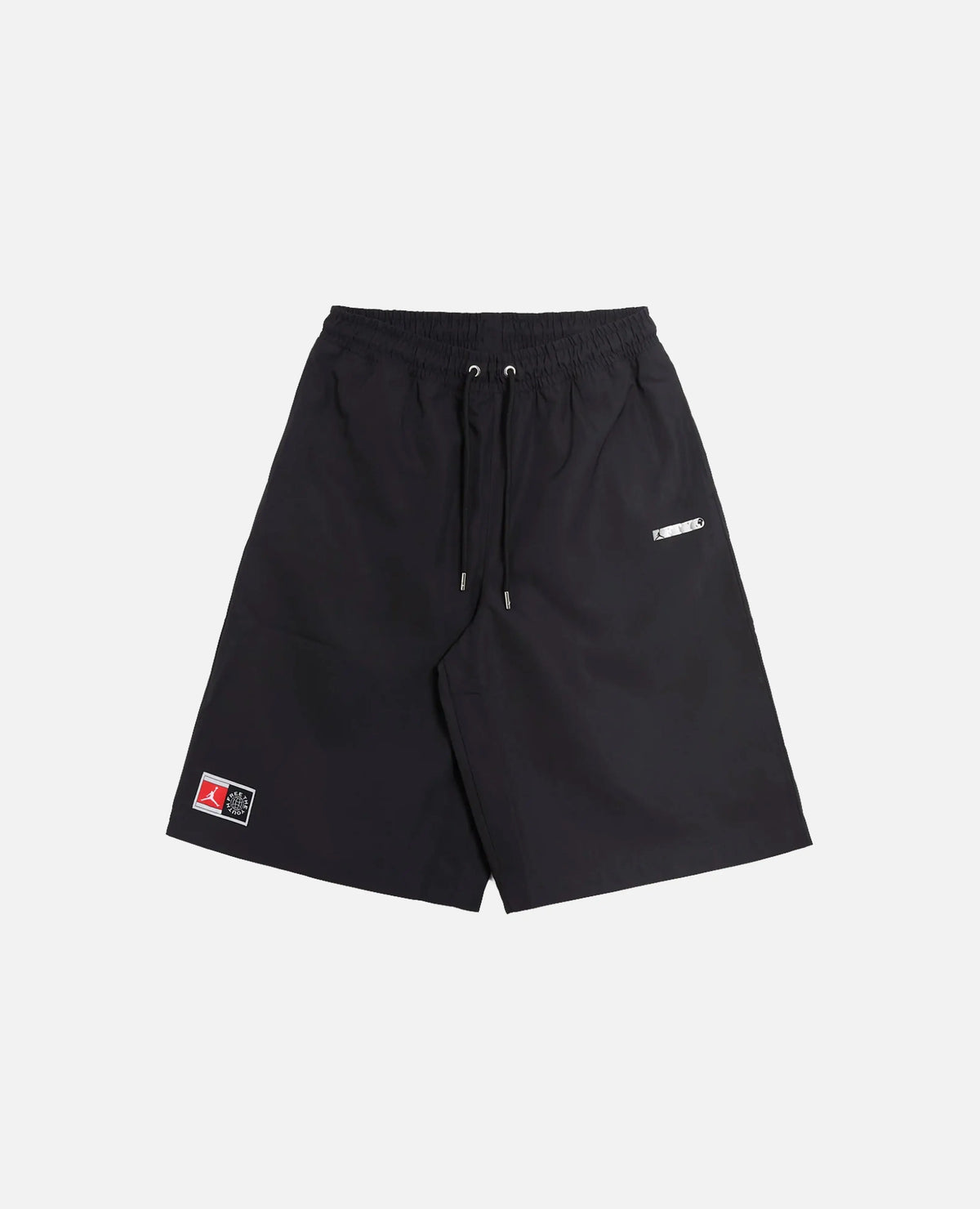 Front view of Nike Jordan x FTY black shorts with an elastic drawstring waist and logo patches.