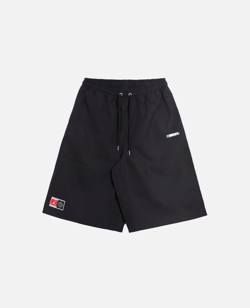 Front view of Nike Jordan x FTY black shorts with an elastic drawstring waist and logo patches.