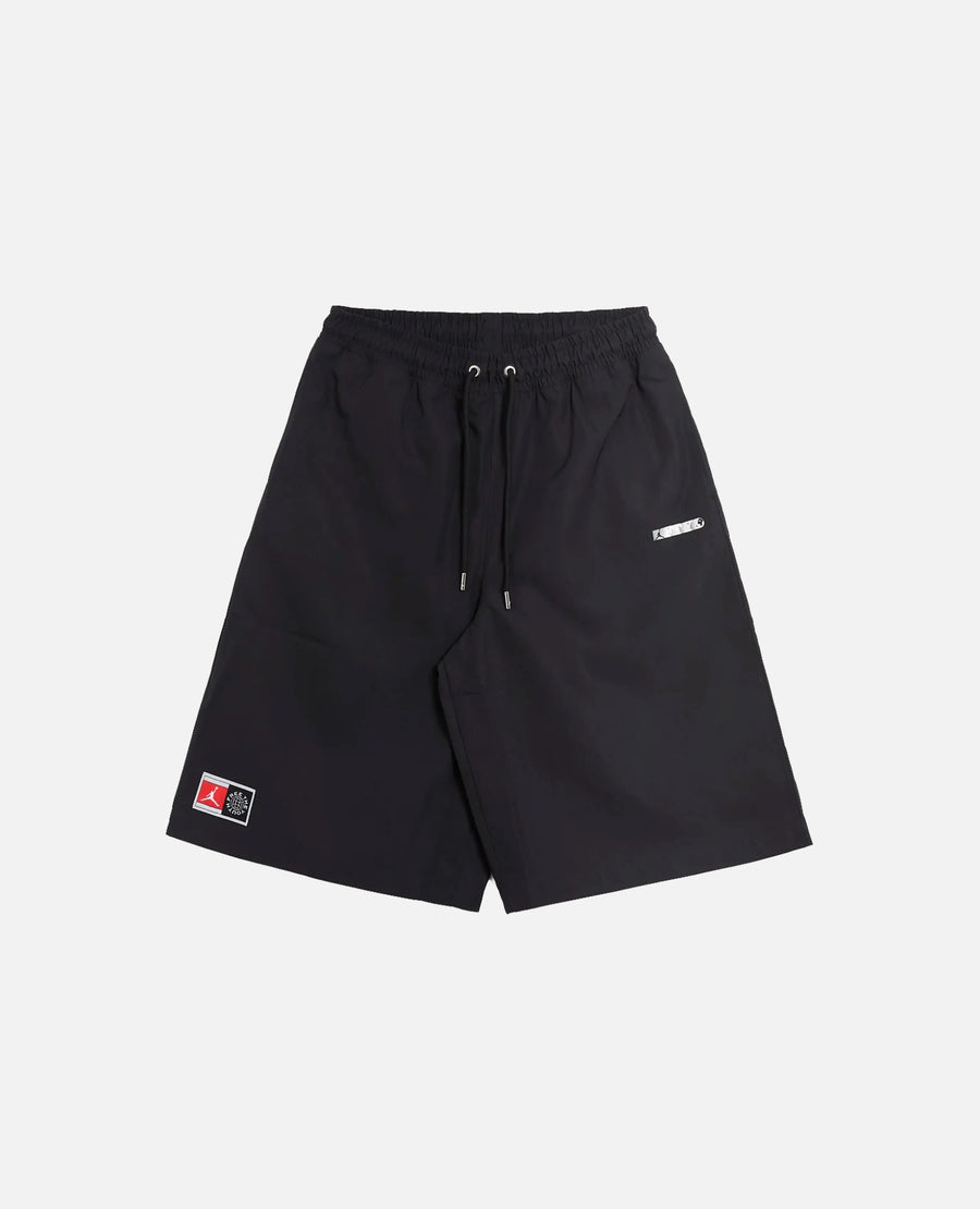 Front view of Nike Jordan x FTY black shorts with an elastic drawstring waist and logo patches.