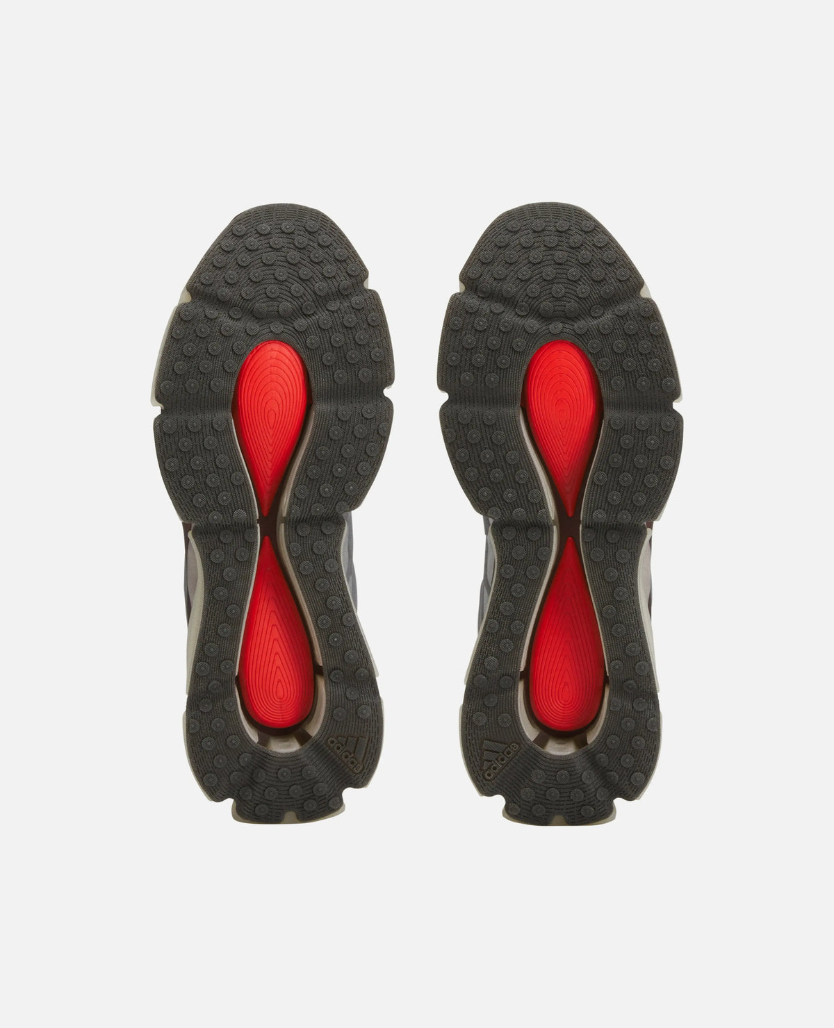 Bottom view of Adidas Chavarria Megaride sneakers showing textured black rubber outsoles with vibrant red inserts.