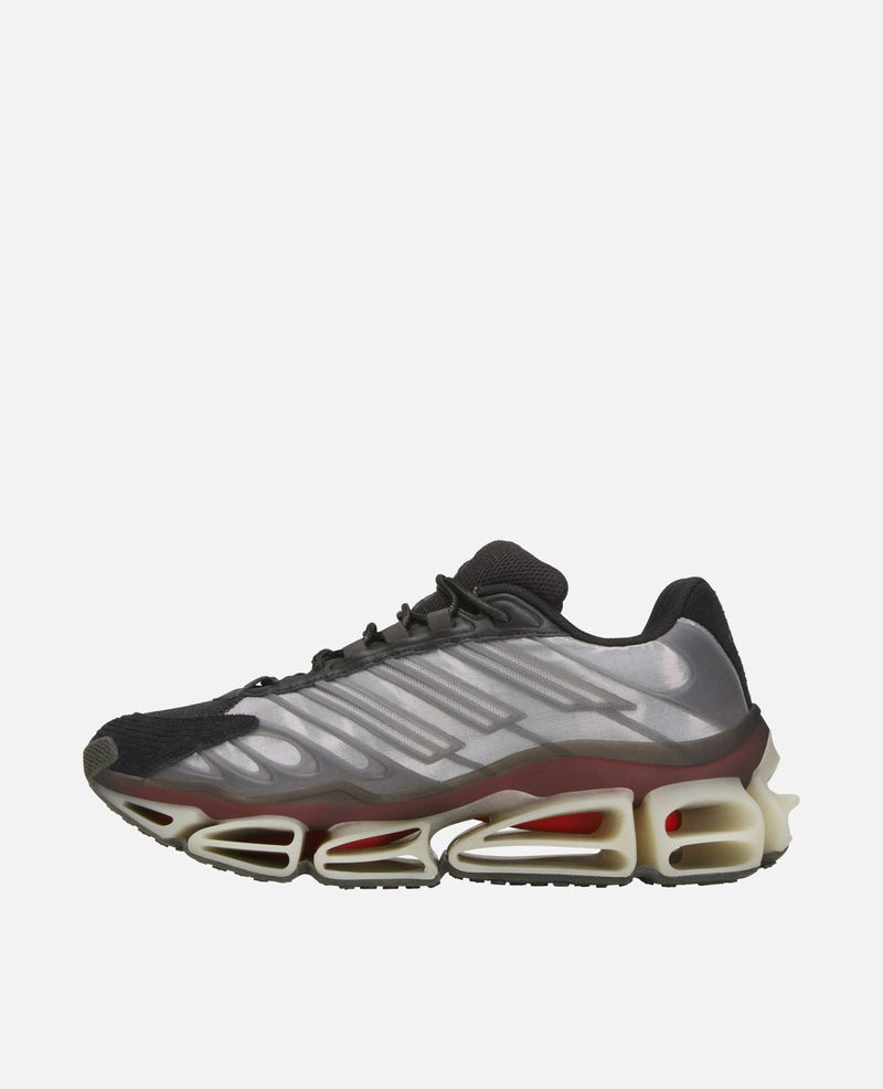 Side view of the adidas Chavarria Megaride sneaker in black, grey, and off-white with a sculpted sole.
