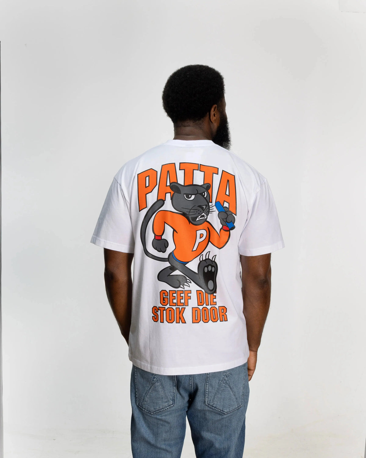 Back view of white Patta x NLWB T-shirt with orange cartoon panther graphic worn by a model.