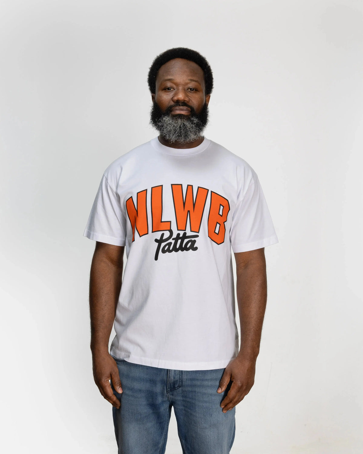 Front view of the white Patta x NLWB 15th Anniversary t-shirt with orange chest print on a model.