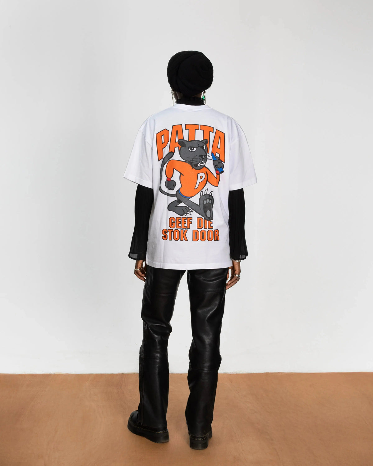 Back view of model wearing the white Patta x NLWB 15th Anniversary graphic t-shirt.