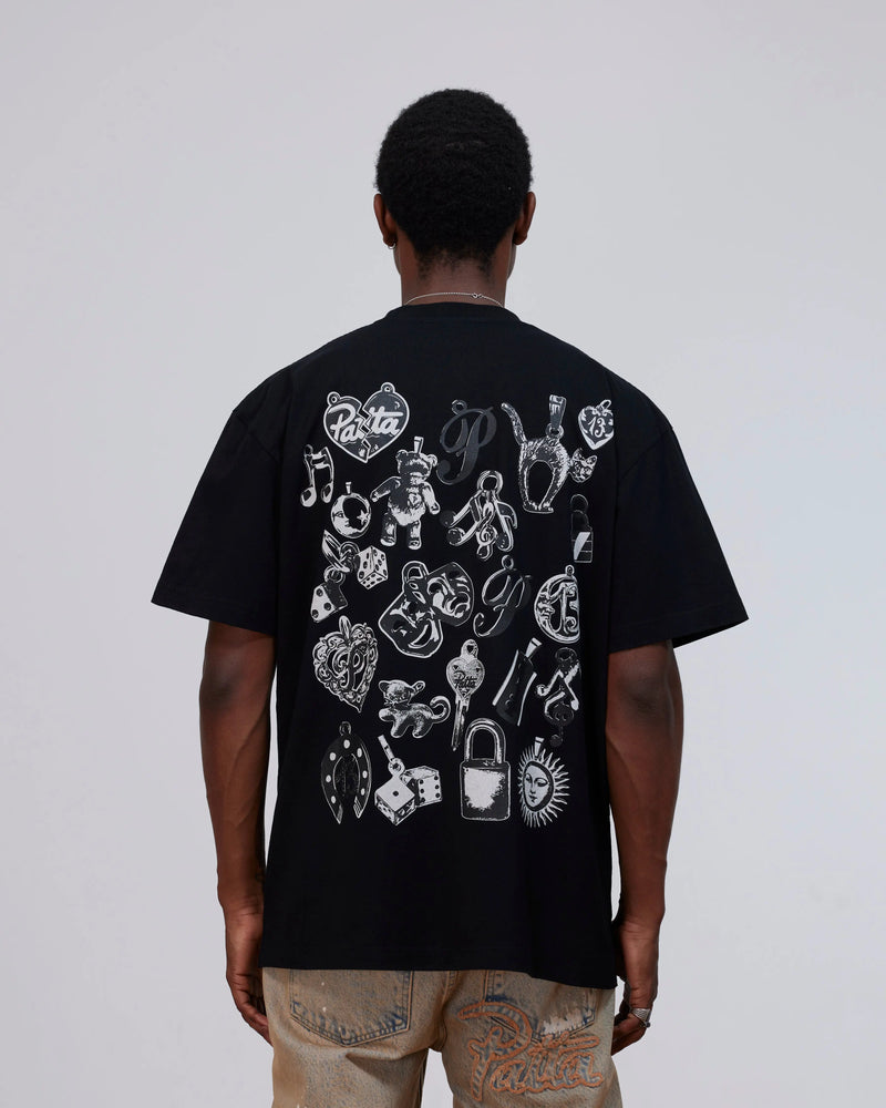 Back view of model wearing the black Patta Charm T-Shirt with white charms graphic print.